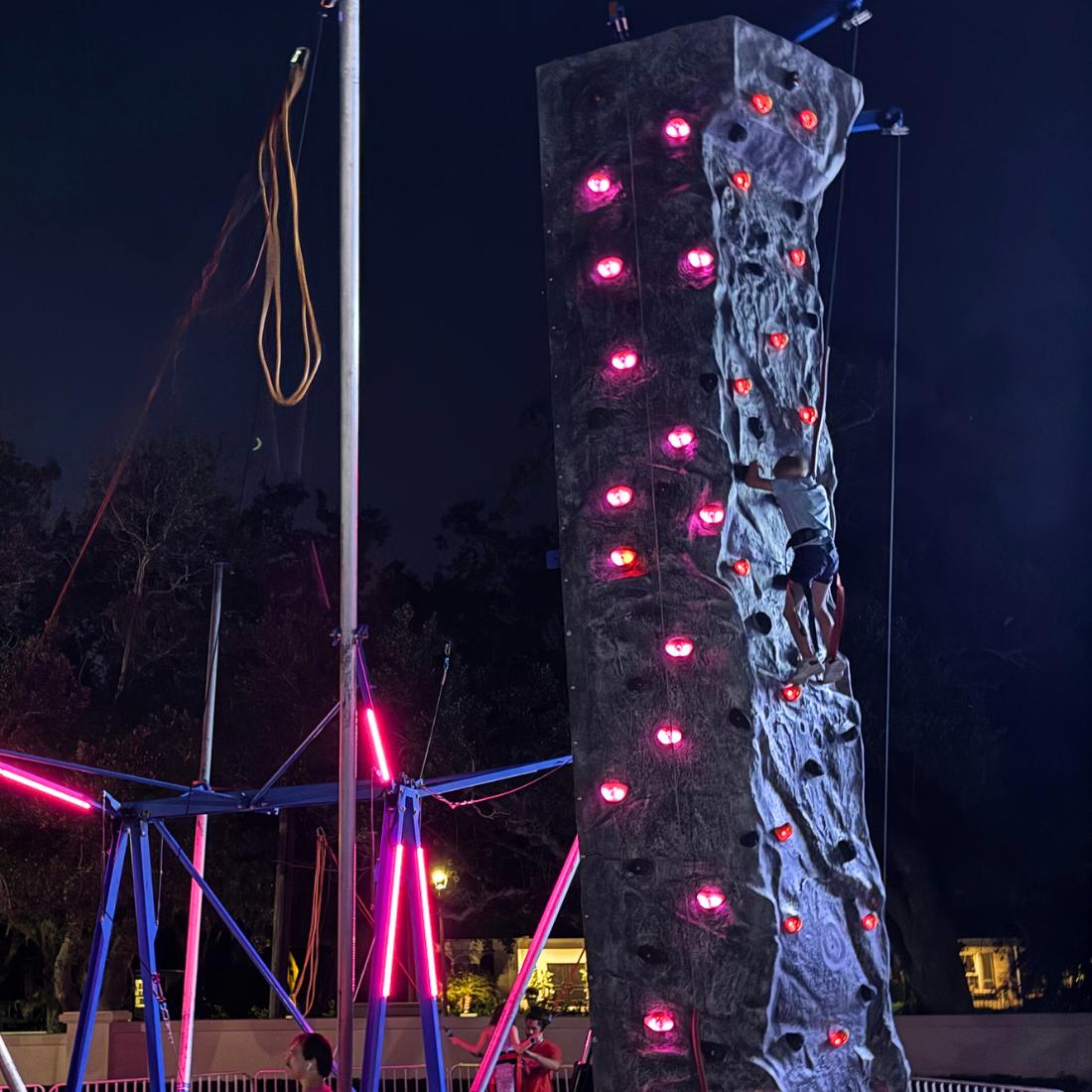 Man climbing rock wall rental at night